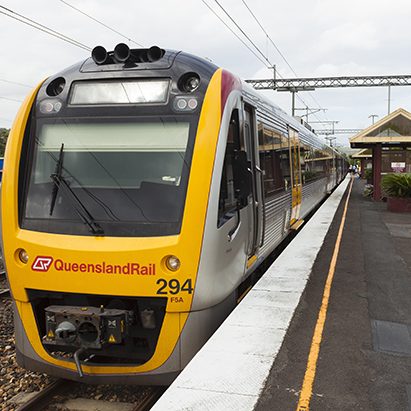 "Nambour, Australia - December 29, 2011: Queensland Rail Passenger train is stopped at the train station in Nambour. Passengers can be seen in the distance."